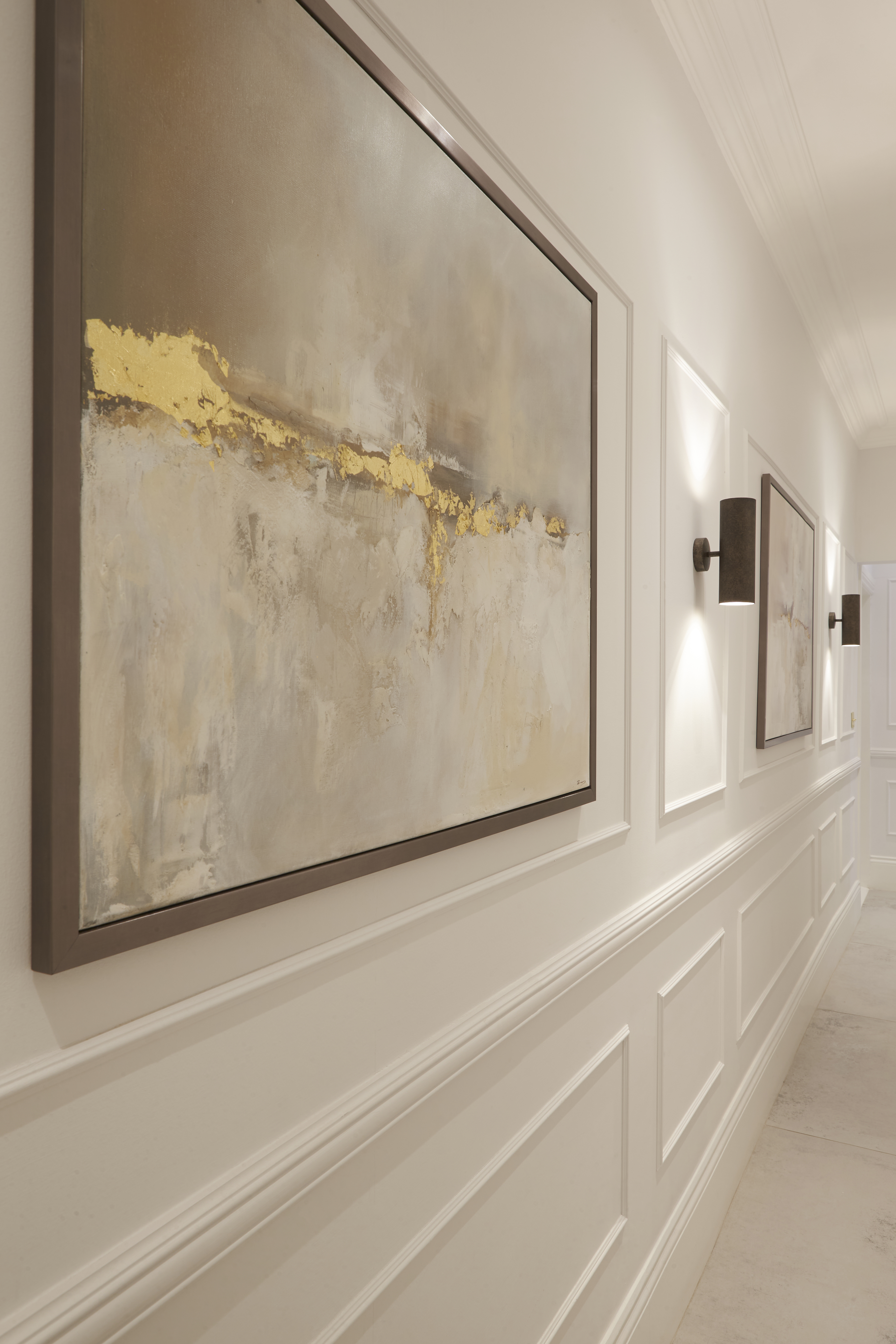 Art gallery in long narrow hallway with wall paneling
