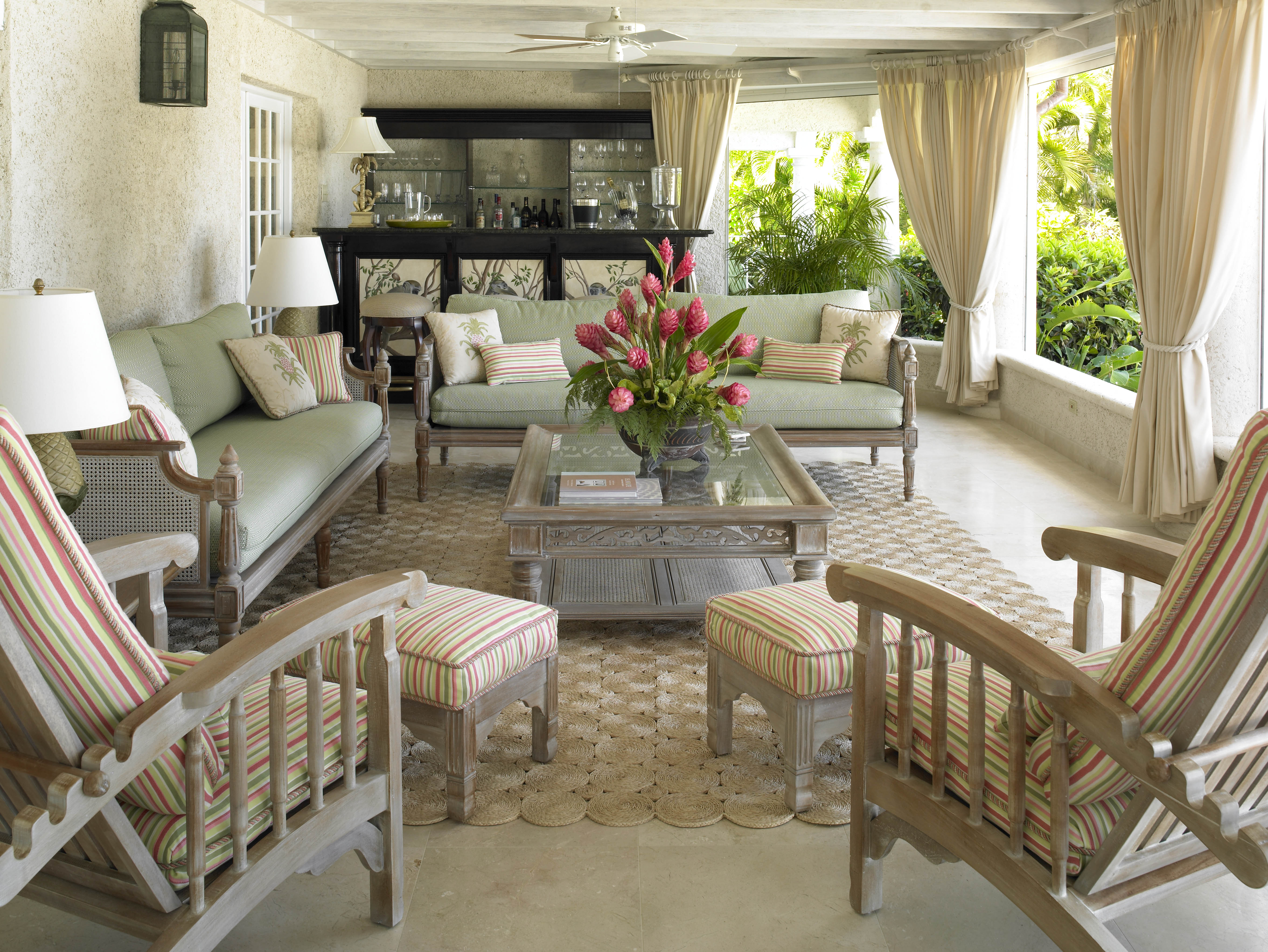 The verandah of this traditional home was re-designed to create three different zones for entertaining.   Here, a comfortable seating area with cane furniture and planter's chair provides a convivial environment for relaxing with friends and family.