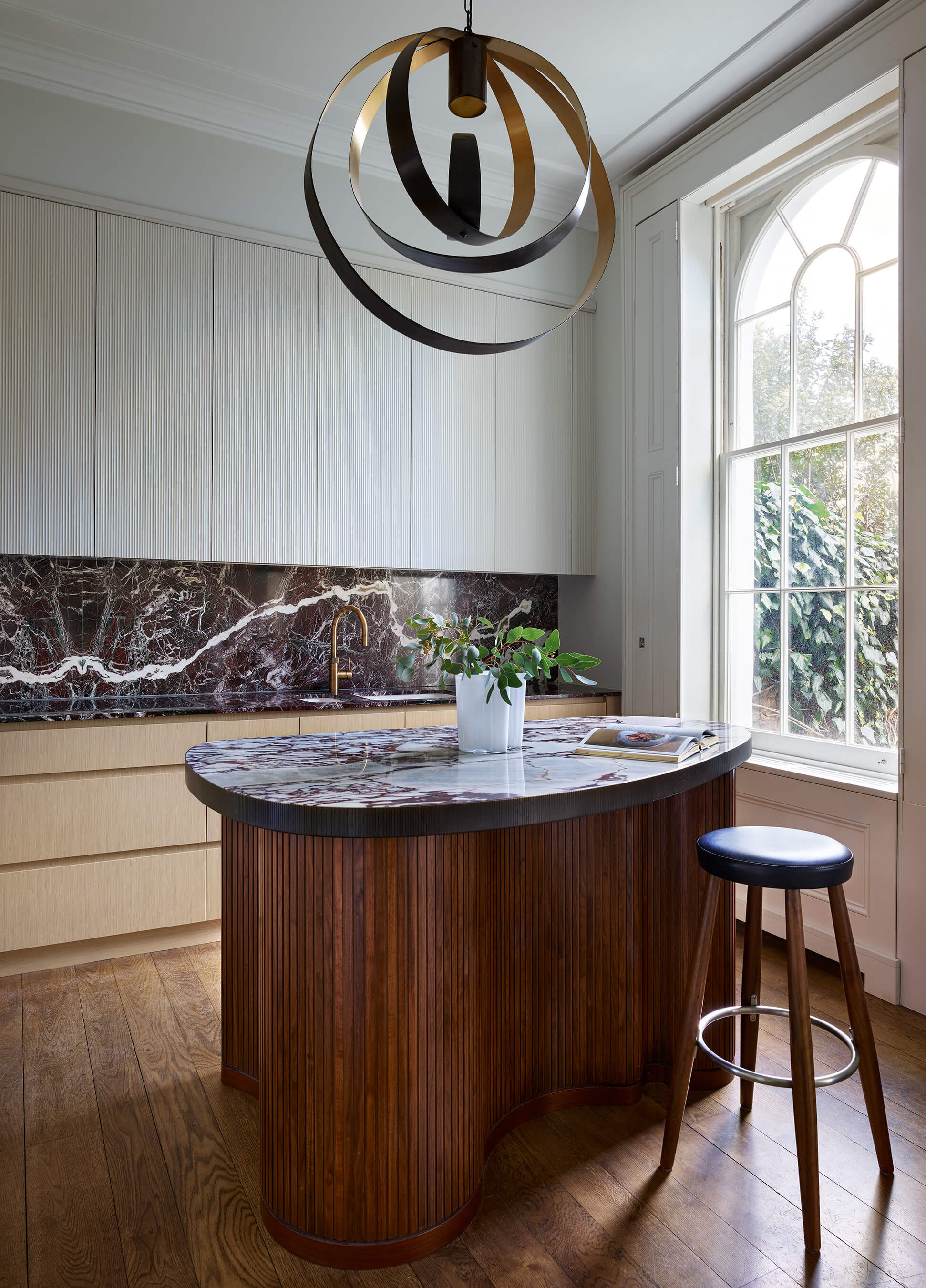 Angled view of a kitchen with a CTO pendant light and view through the window