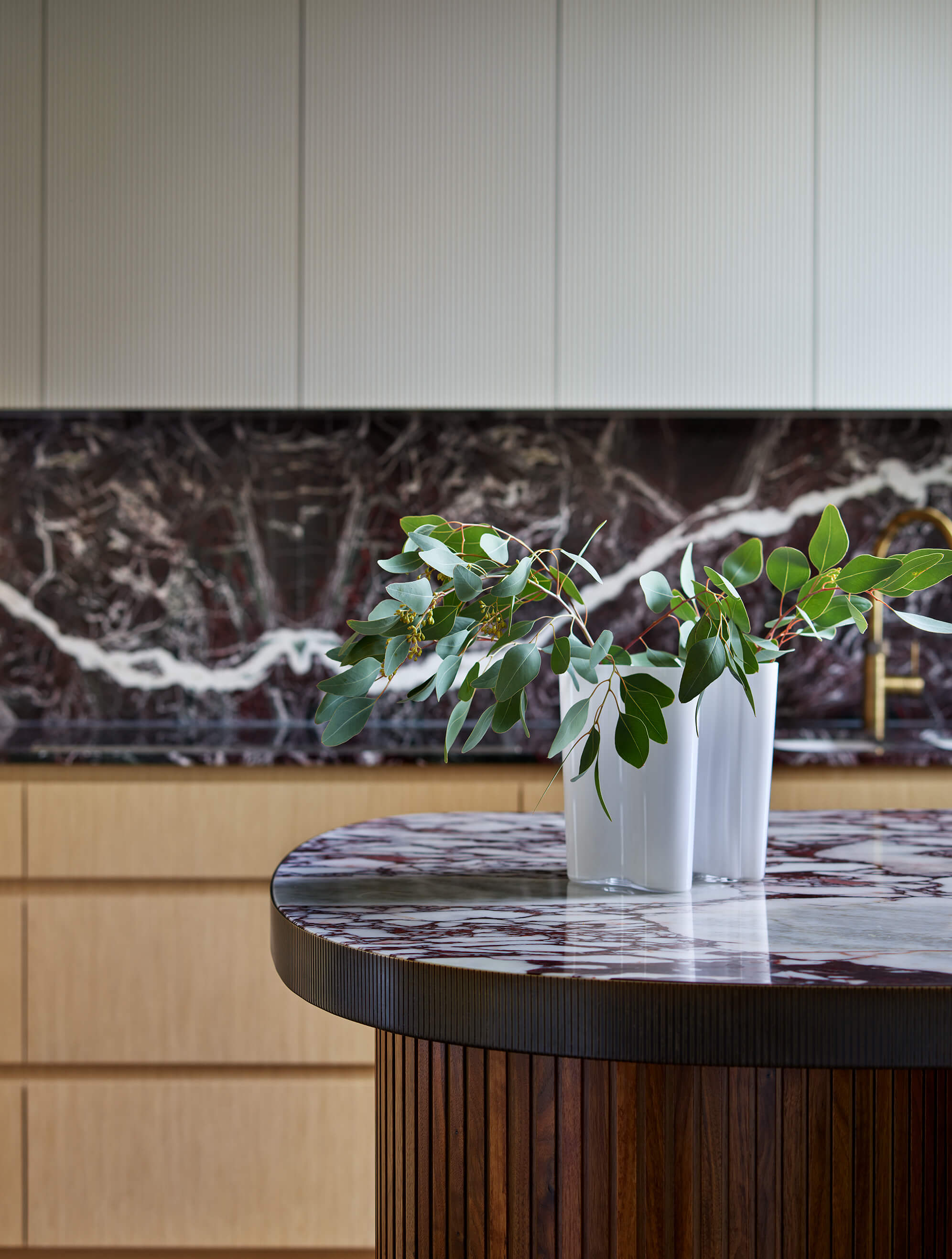 An Alvar Aalto glass vase sitting on the worktop of a kitchen island