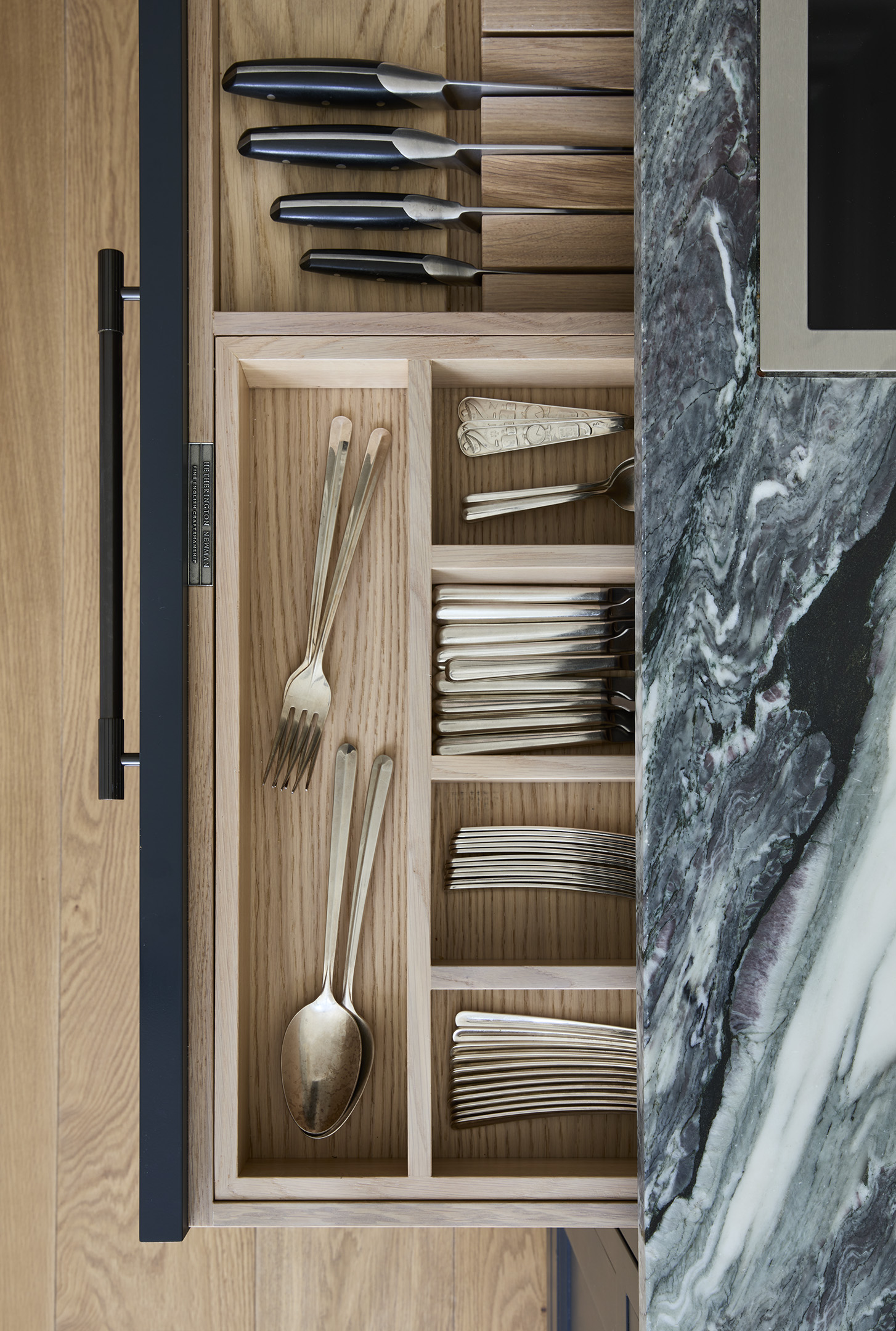 An aerial view into an oak lined cutlery & knife drawer