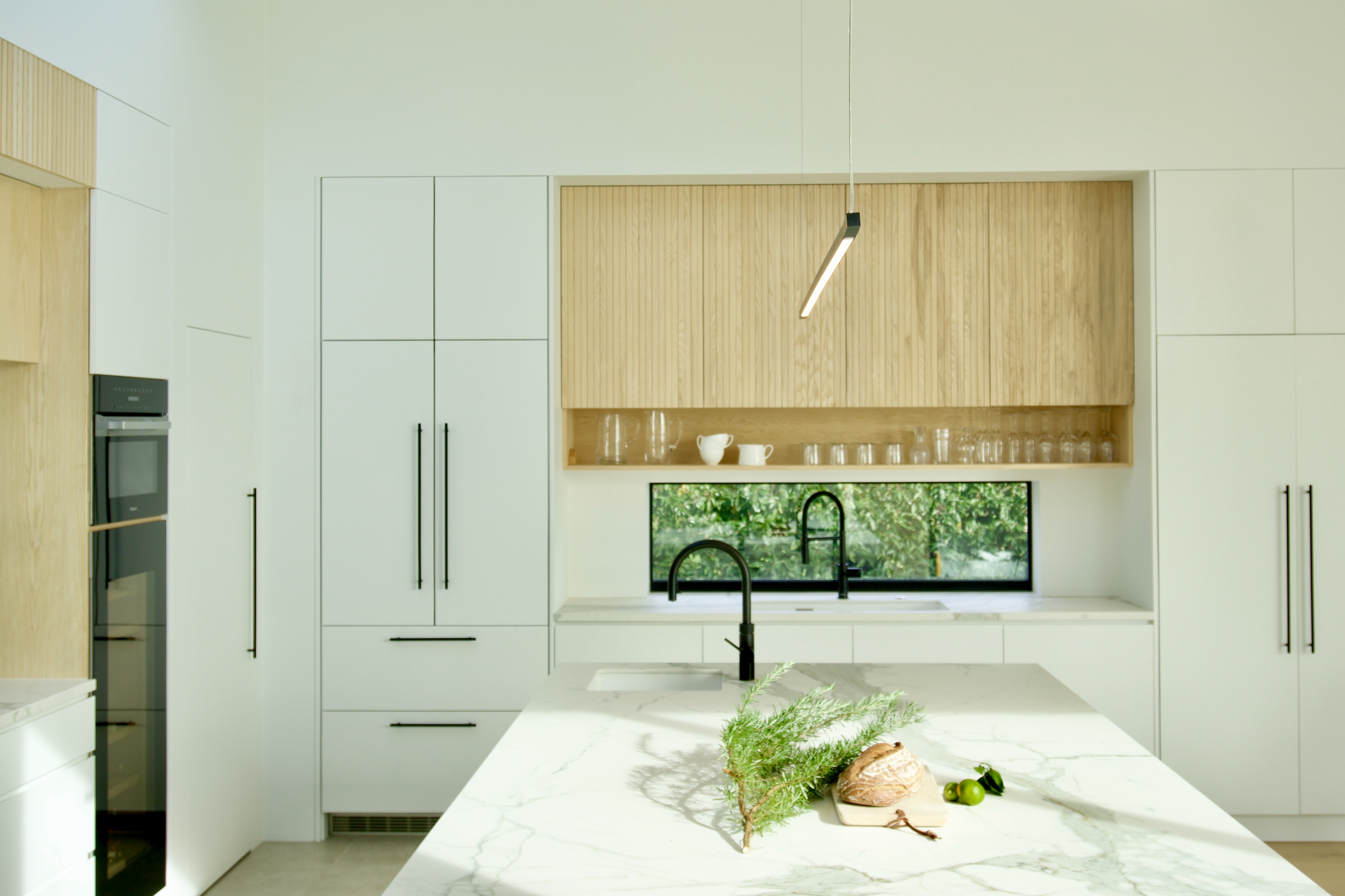 Modern kitchen with white and reeded Ash cupboards and detailing.