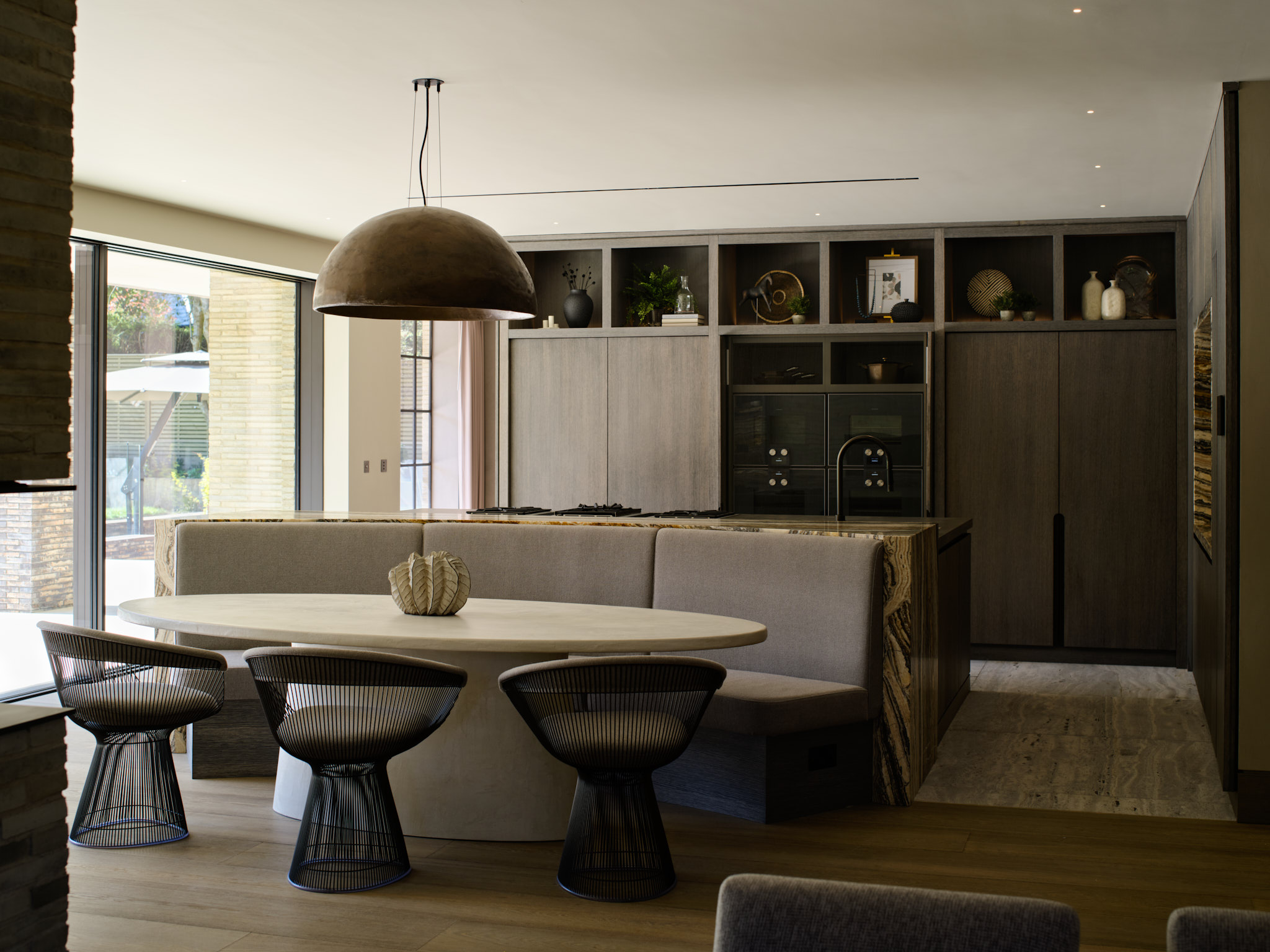 A grey stained oak minimalist style kitchen with dining table & banquette seating