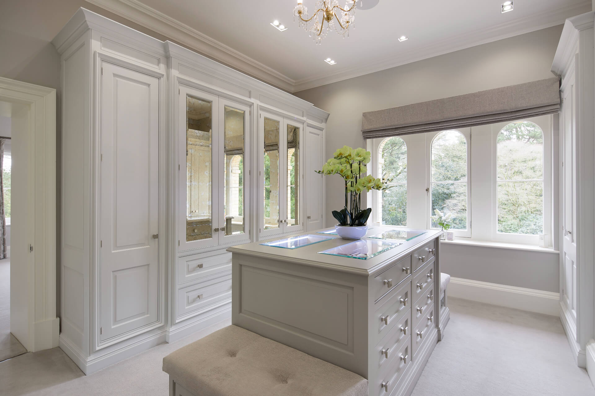 A White painted dressing room by Hetherington Newman with wardrobes and a central storage unit