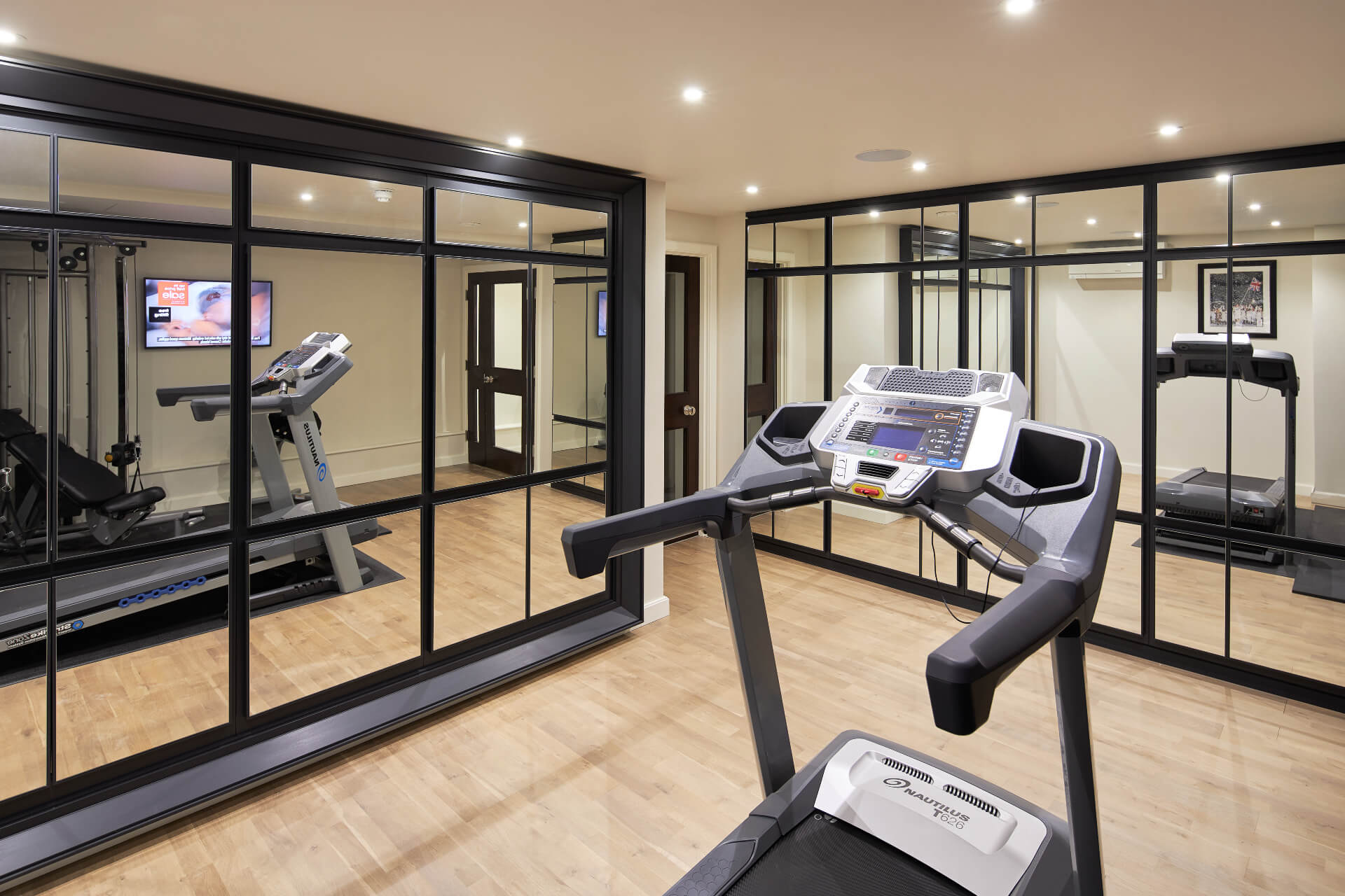 Mirror fronted cupboards in a home gym by Hetherington Newman