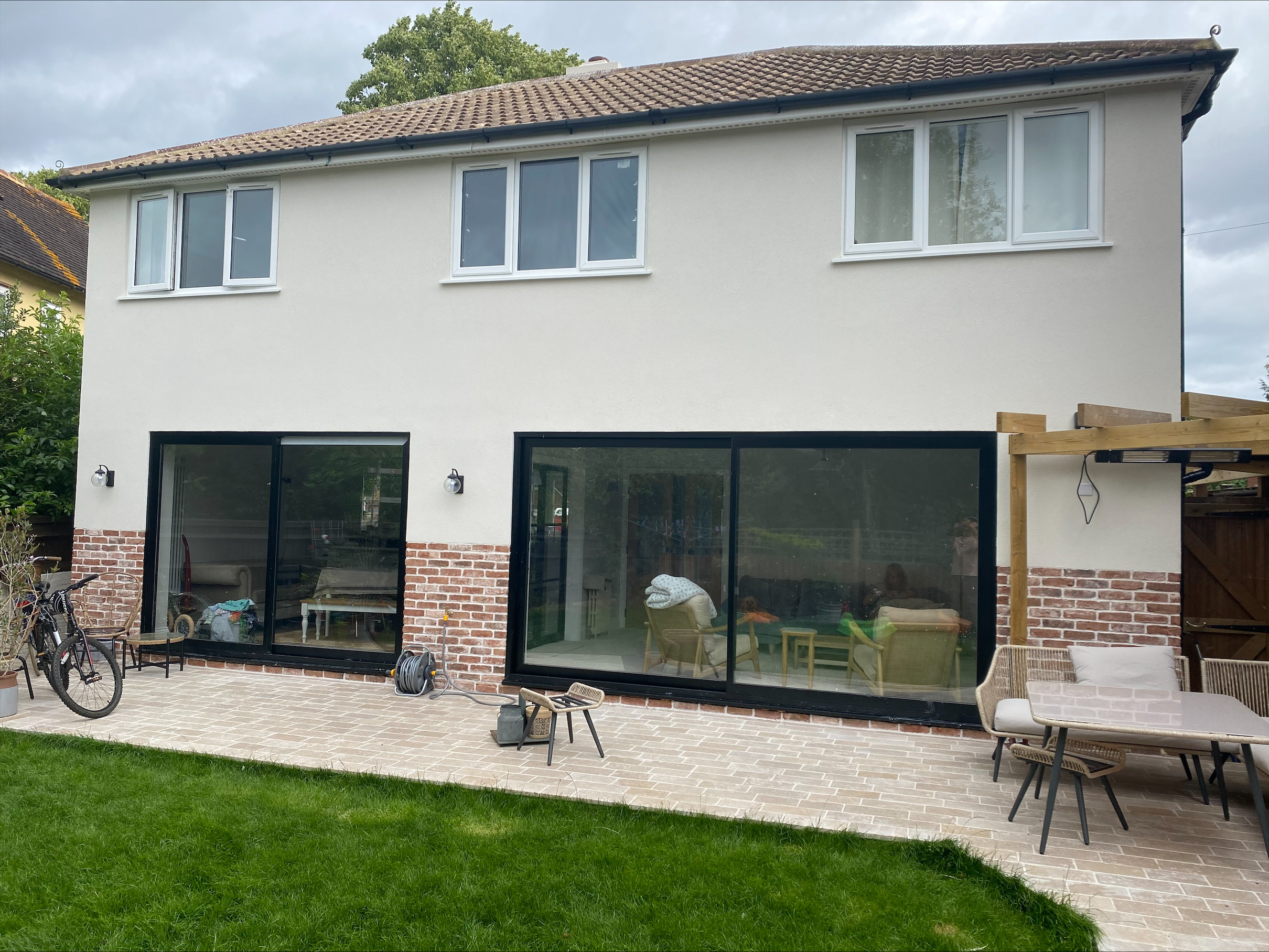 Rear of a home, clad with brick slips up to a meter then rendered