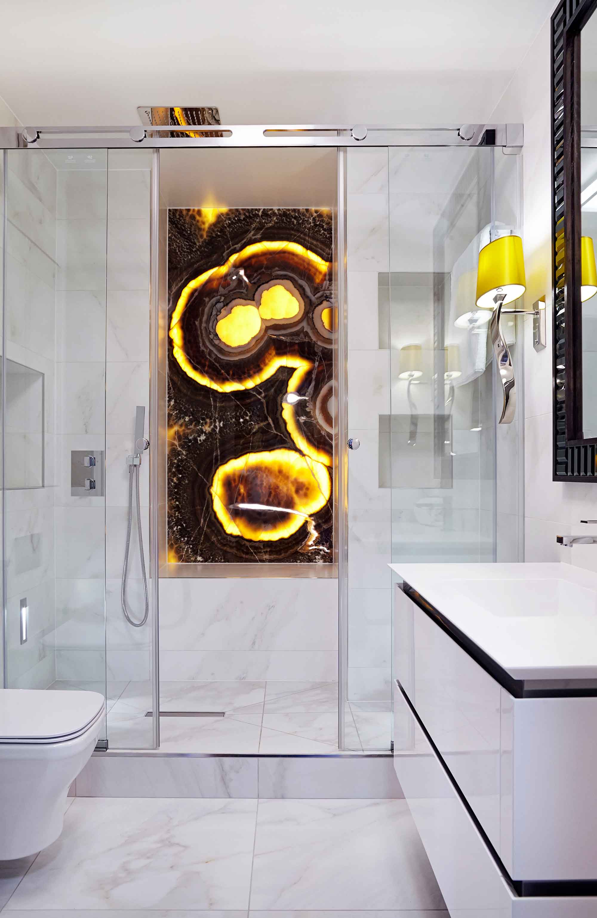 The back-lit onyx bathes the bathroom in warm light
