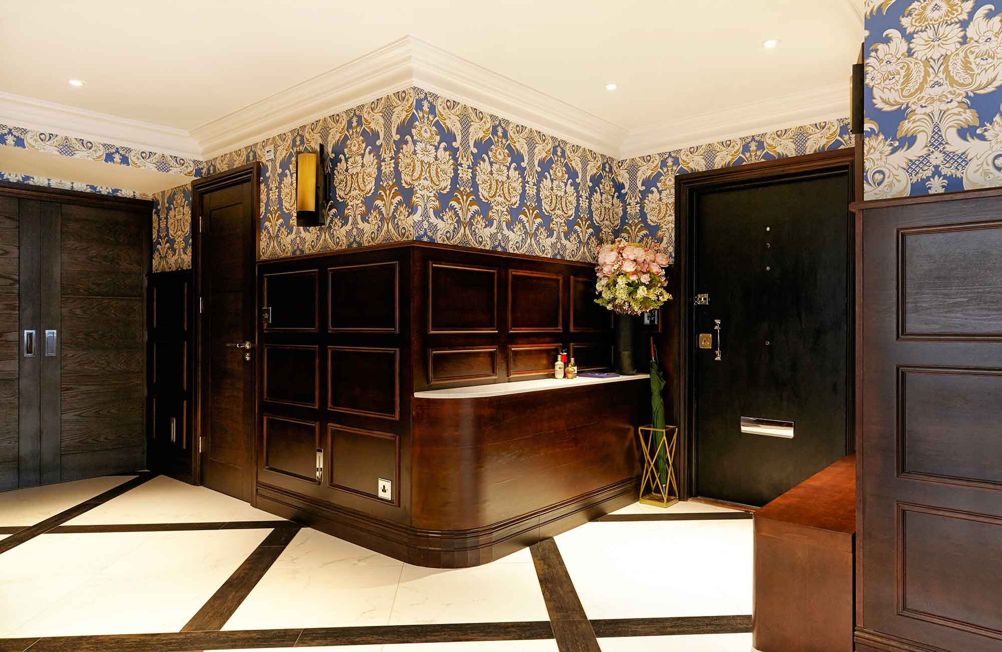 Porcelanosa tiles, Cole and Sons wallpaper, Porta Romana lighting and bespoke wood panelling make quite the entrance