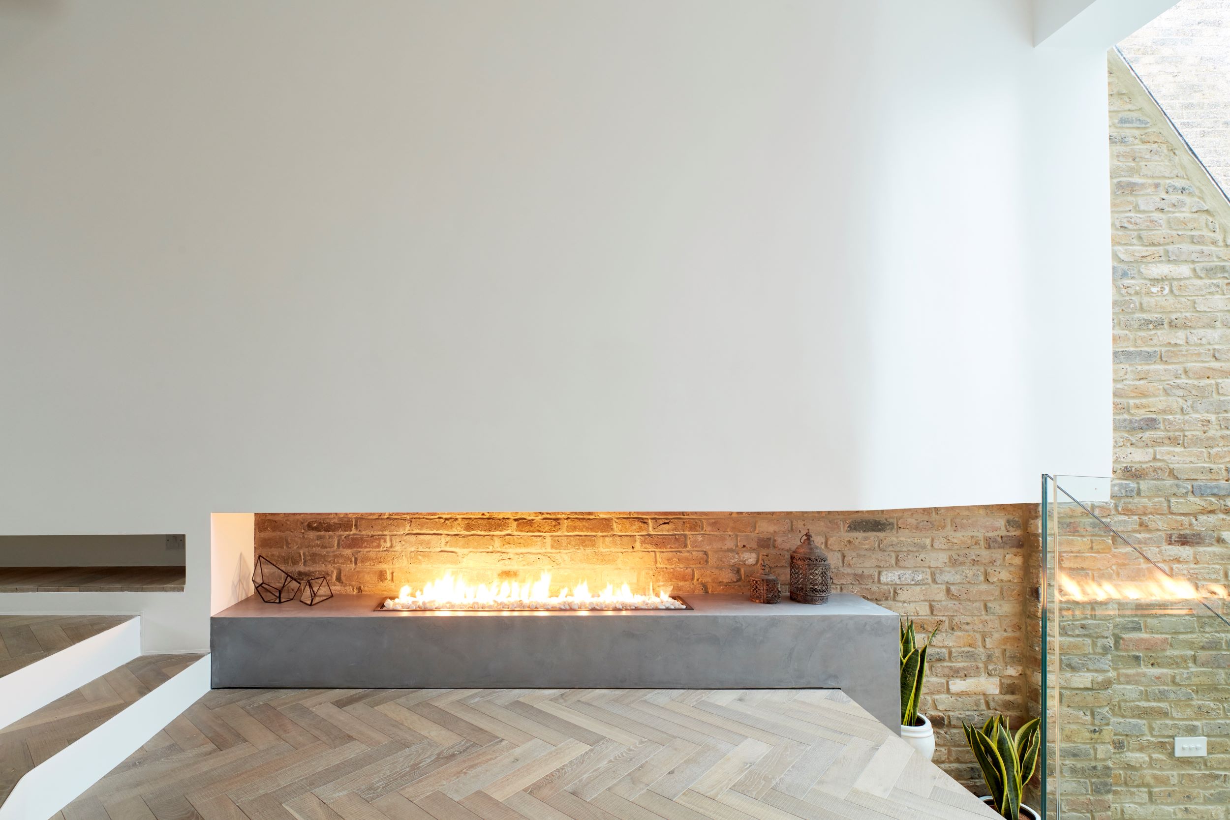 Modern open fire place and herringbone floor.
