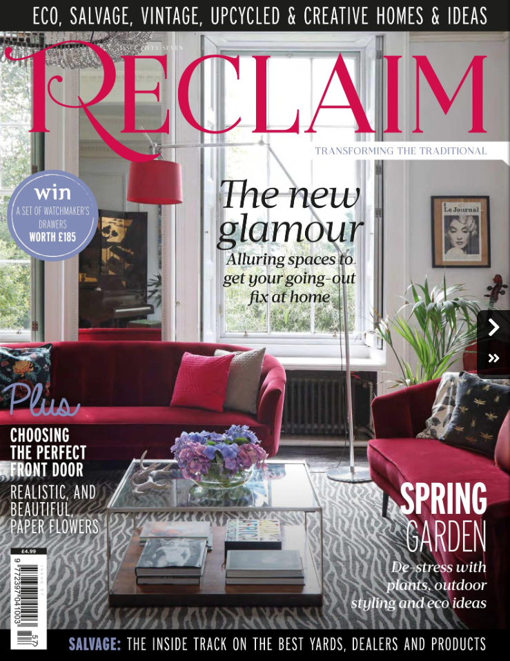 A pair of red sofas in a sitting room on the cover of Reclaim magazine