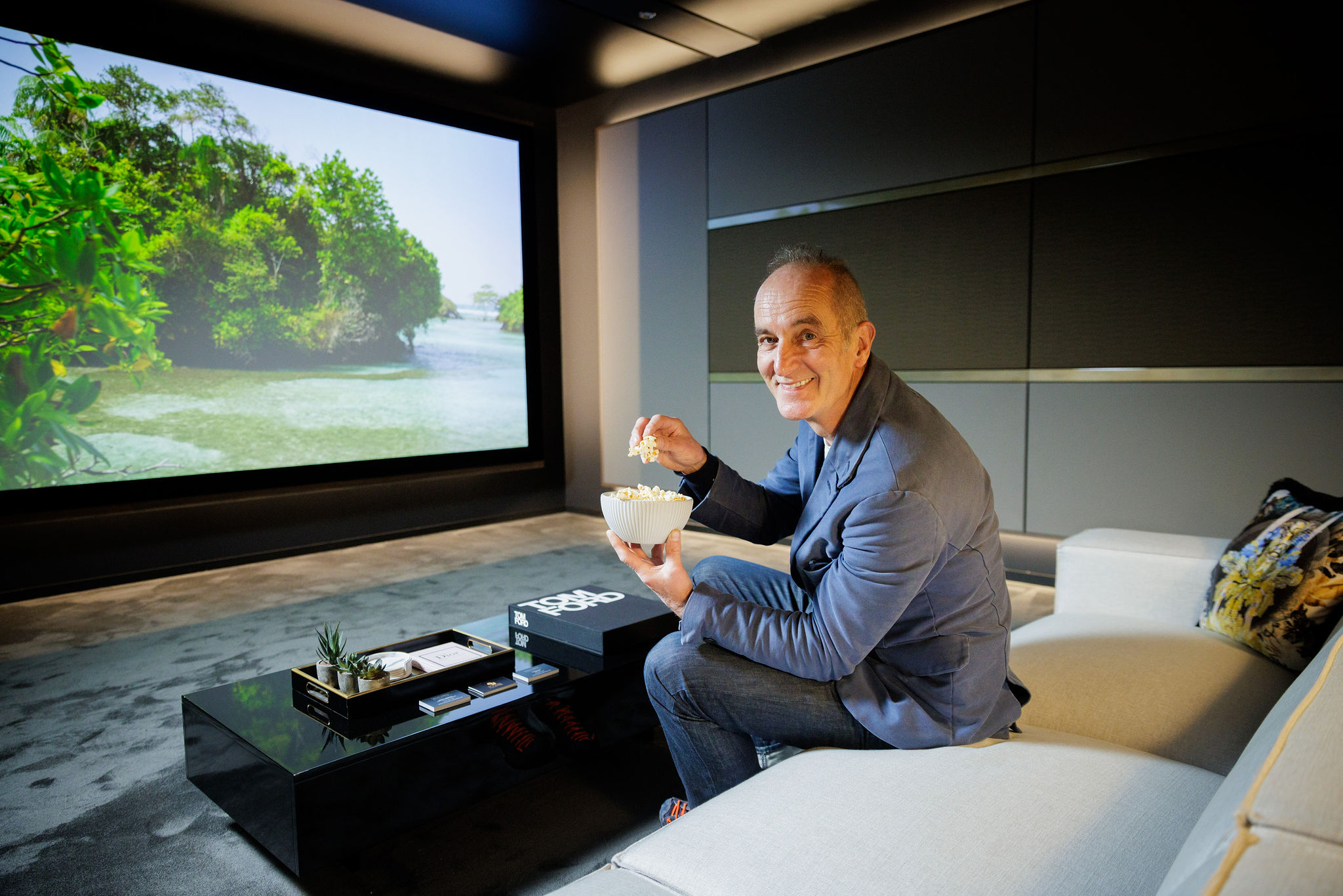 Kevin McCloud enjoying ExCeL London's first cinema room, created by BUTLER HARWELL for Grand Designs Live 2024