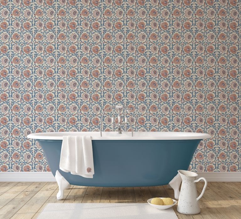 Blue freestanding bath with red flower wallpaper behind it.