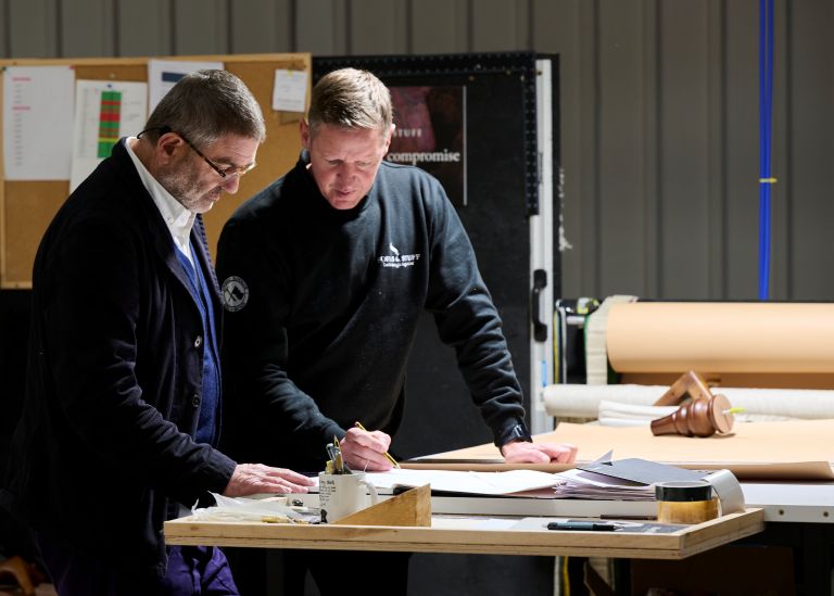 Two Sofas & Stuff employees discussing plans at a worktable.