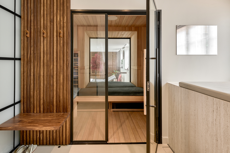Glass door open onto a wooden themed spa space