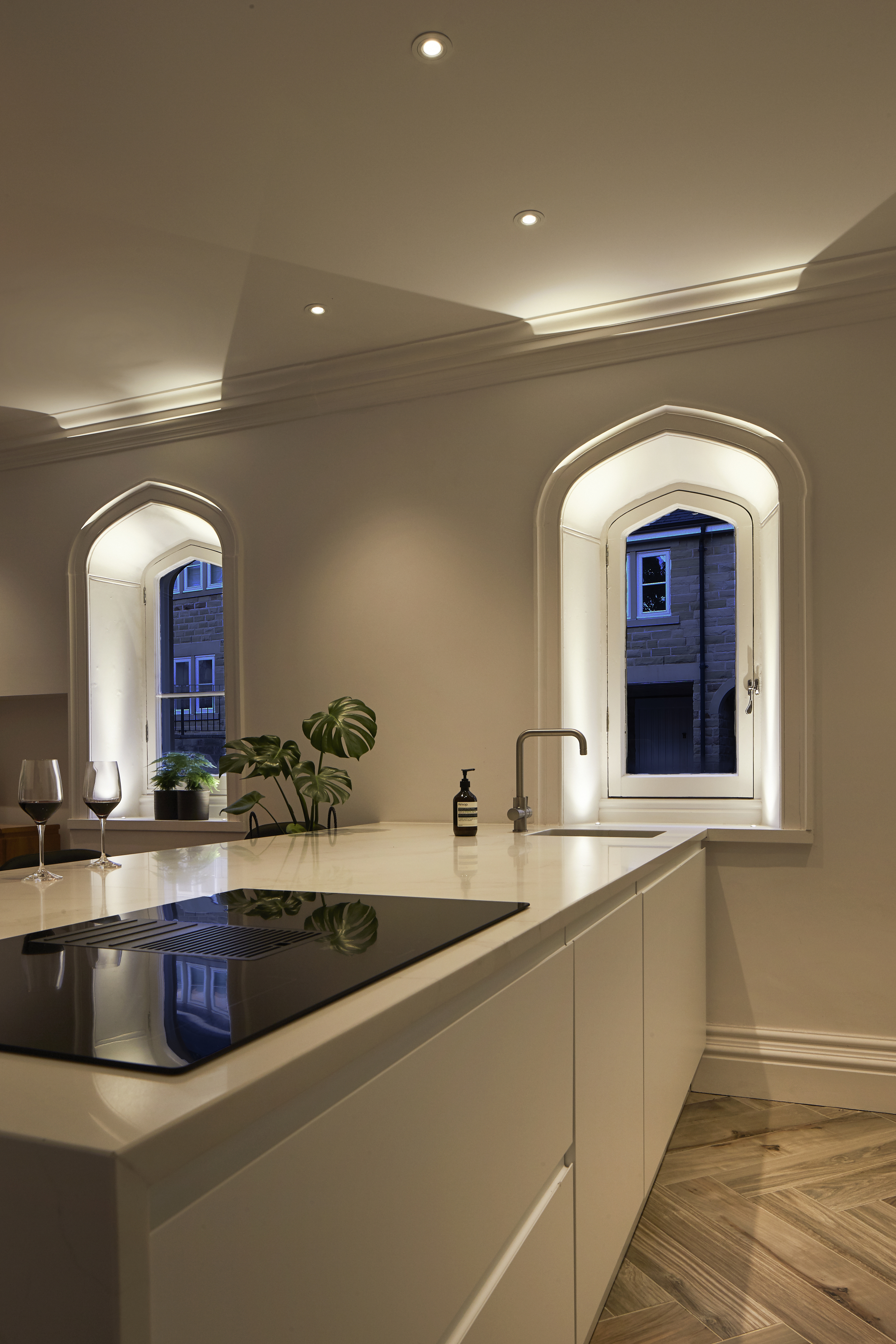 Lighting design in contemporary white kitchen with large island