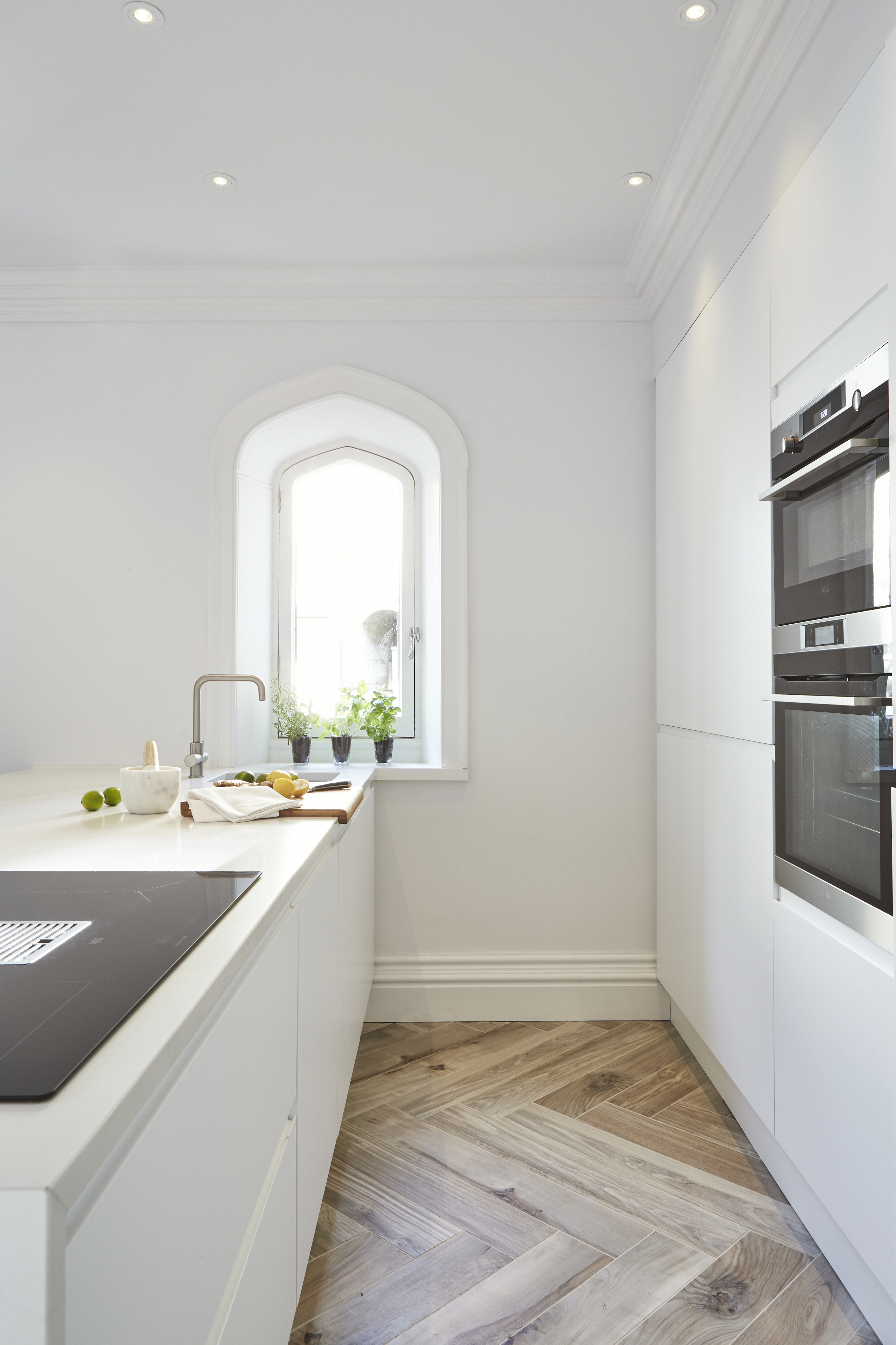 Contemporary white kitchen built in cupboards large island herringbone porcelain tile floor