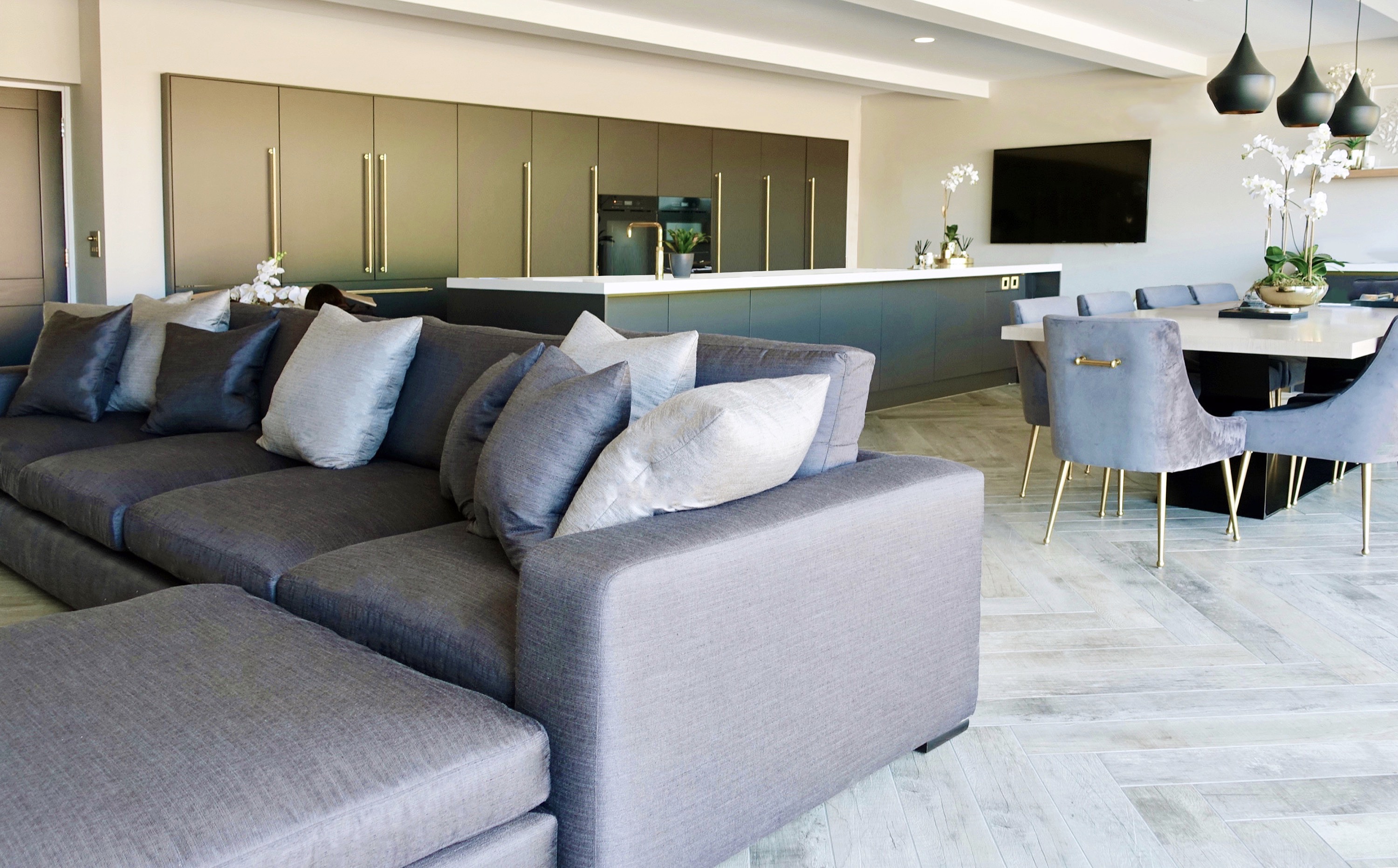 contemporary open plan living with blue kitchen herringbone tile floor l-shape sofa