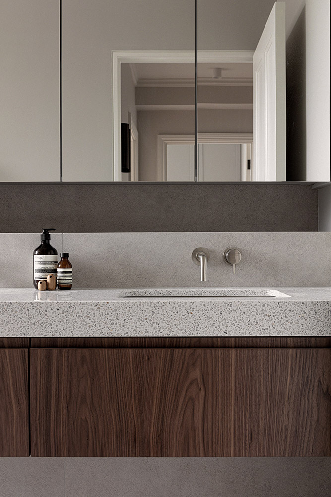 A sophisticated contemporary bathroom showcasing a touch of luxury with a walnut vanity and elegant terrazzo accents.