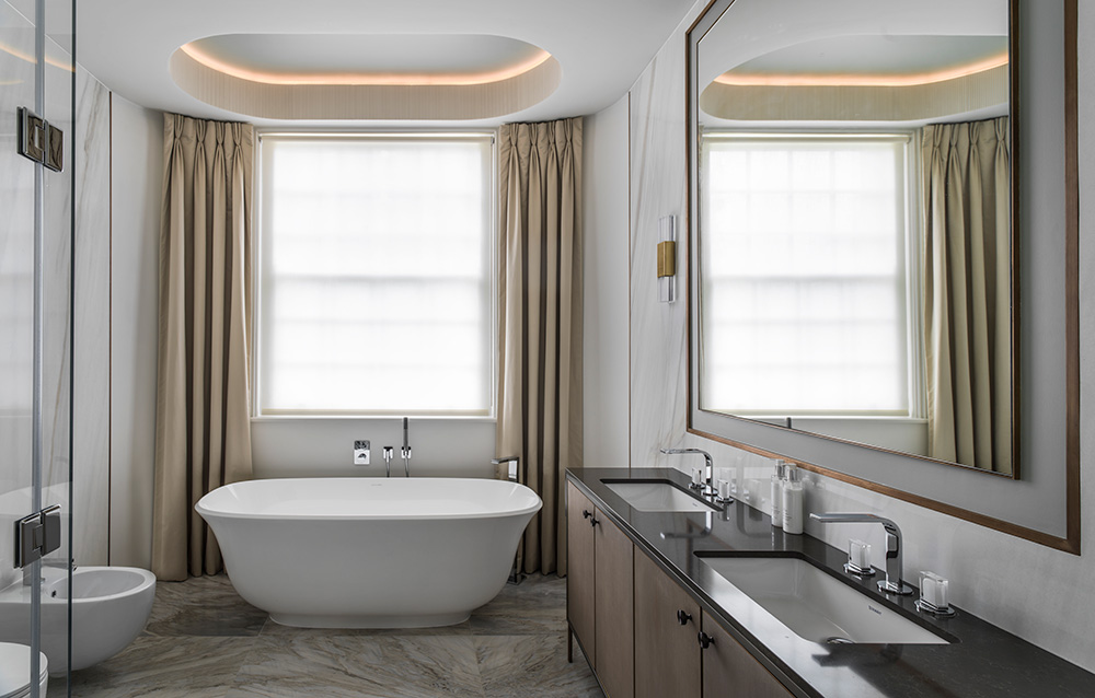 luxury bathroom with large bay window, dress curtains and oval freestanding bath