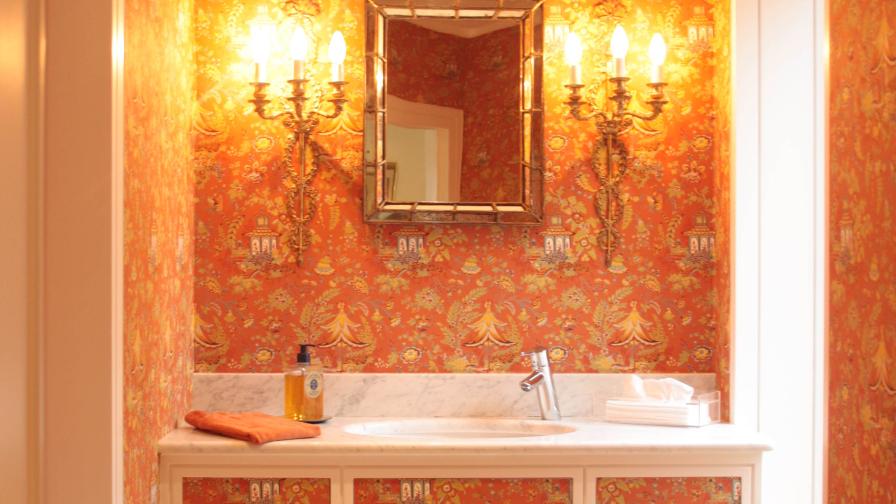 The Cloakroom's burnt orange Chinoiserie wallpaper is freshened by the white bathroom marble