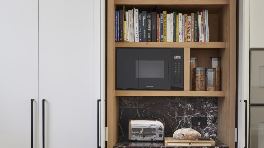 An oak lined breakfast unit with pocket doors in a tall run of white cabinets