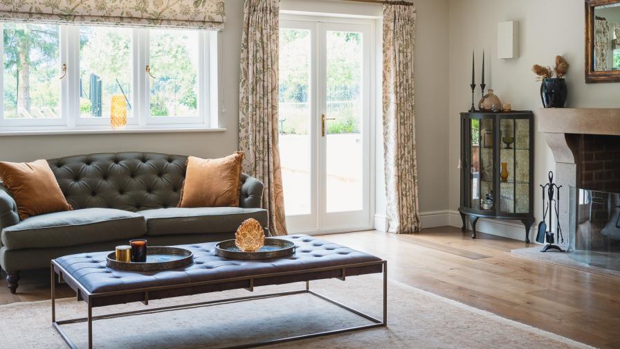 Living room with Chesterfield style sofas, dark wood, leather and  green and yellow ochre colours.