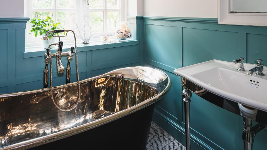 Free standing bath, blue shaker panel walls, chrome and black. 