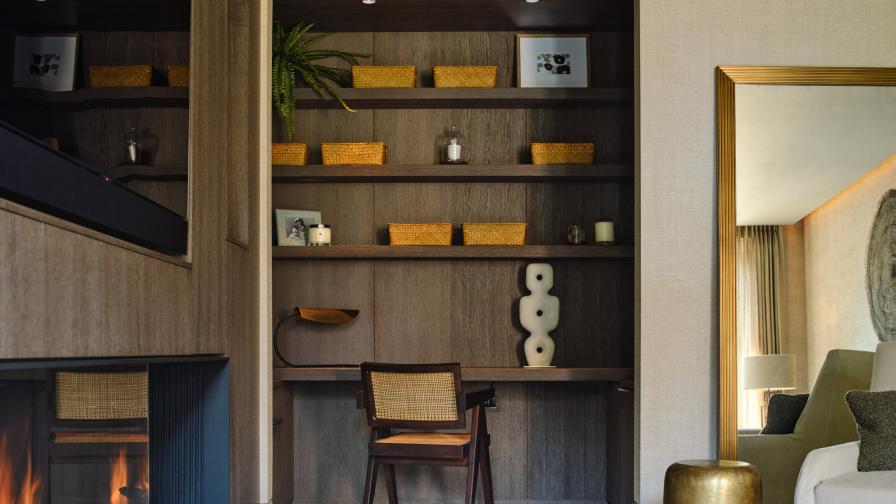 A study area with fitted desk and shelves above in dark stained oak