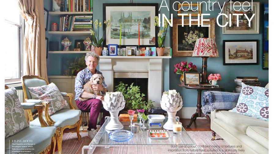 Paul Hawkins and his dog sitting in the living room at his pretty Chelsea home