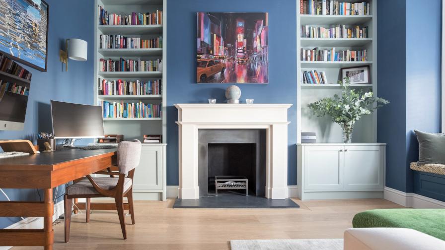 Blues and Greens mix in the home office. Bespoke joinery bookshelves flank the fireplace and set the stage for the Mid-Century Modern artwork and furniture