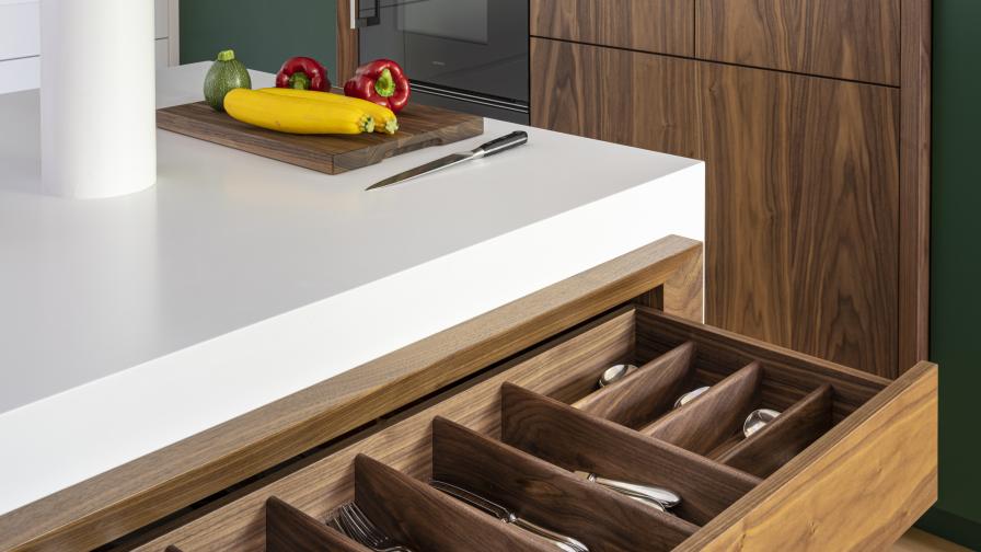 Walnut cutlery drawer within a Corian island