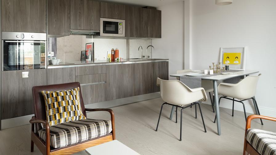 Modern British open plan living room, dining room & kitchen featuring Italian Kitchen units & antique mirror glass splash back.