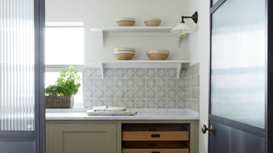 View into a kitchen larder with herringbone parquet .