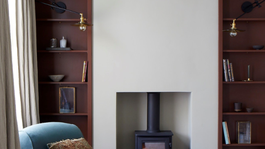 Front room interior with smoked oak floor and woodburning stove , featuring a chair upholstered in blue linen.