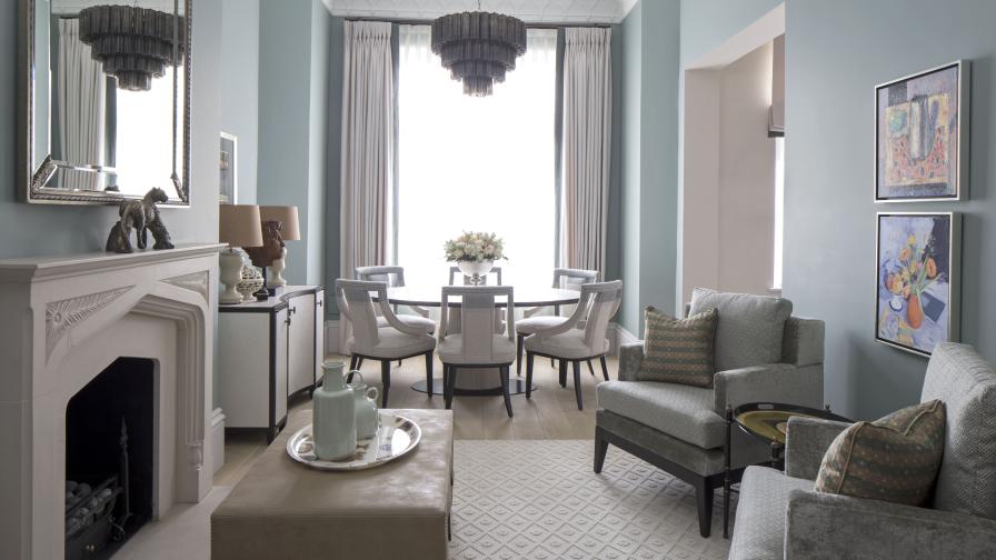 elegant living room with pale blue walls, round dining table and glass chandelier