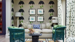 Natalie Tredgett whimsical decoupage wallpaper green garden room with teal painted canned chairs and Swedish flatweave rug. A theatrical artistic and modern living room.