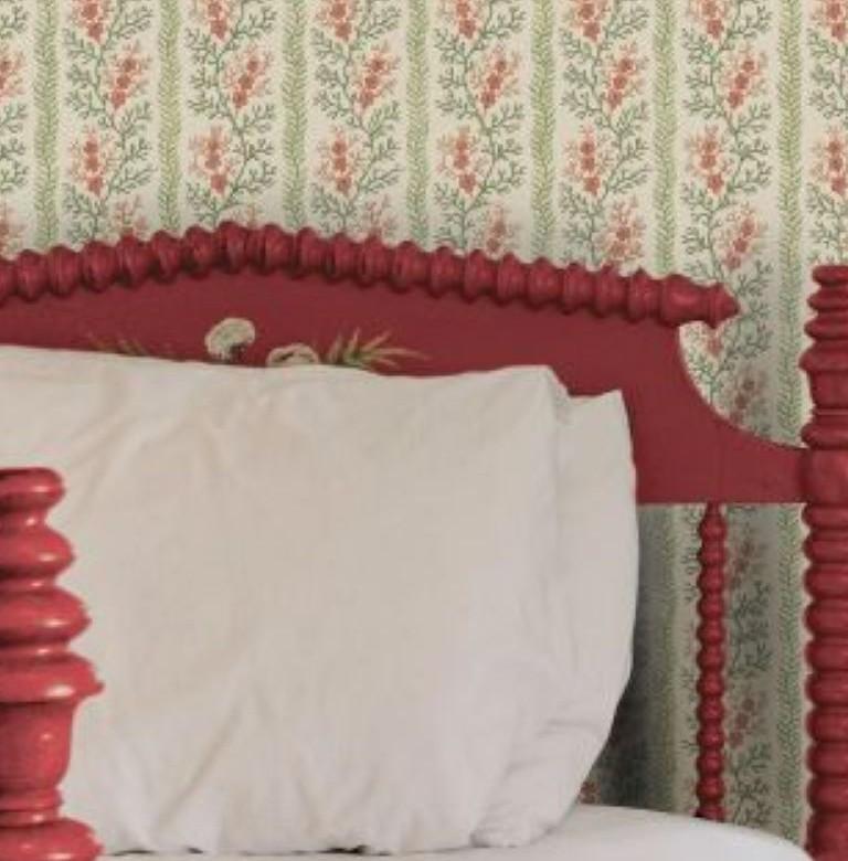 Patterned wallpaper in the background with a bed.