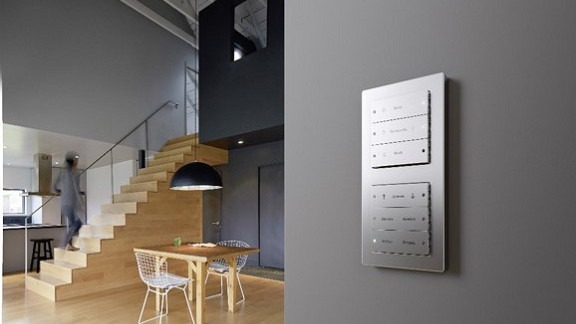 a switch plate on a grey wall in an open plan room with staircase
