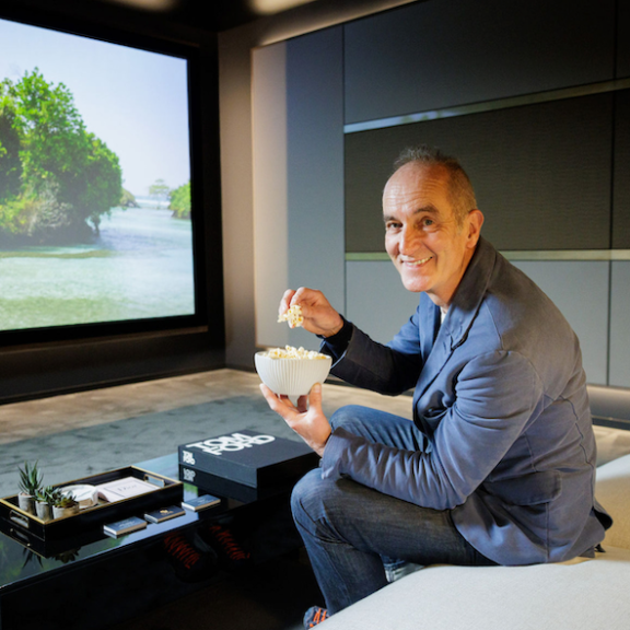 man sitting in front of home cinema screen